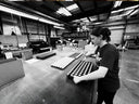 Person working in a warehouse setting with golf ball customization.
