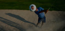 Golfer hitting personalized golf ball with custom design showcasing Golf Swag's customization service